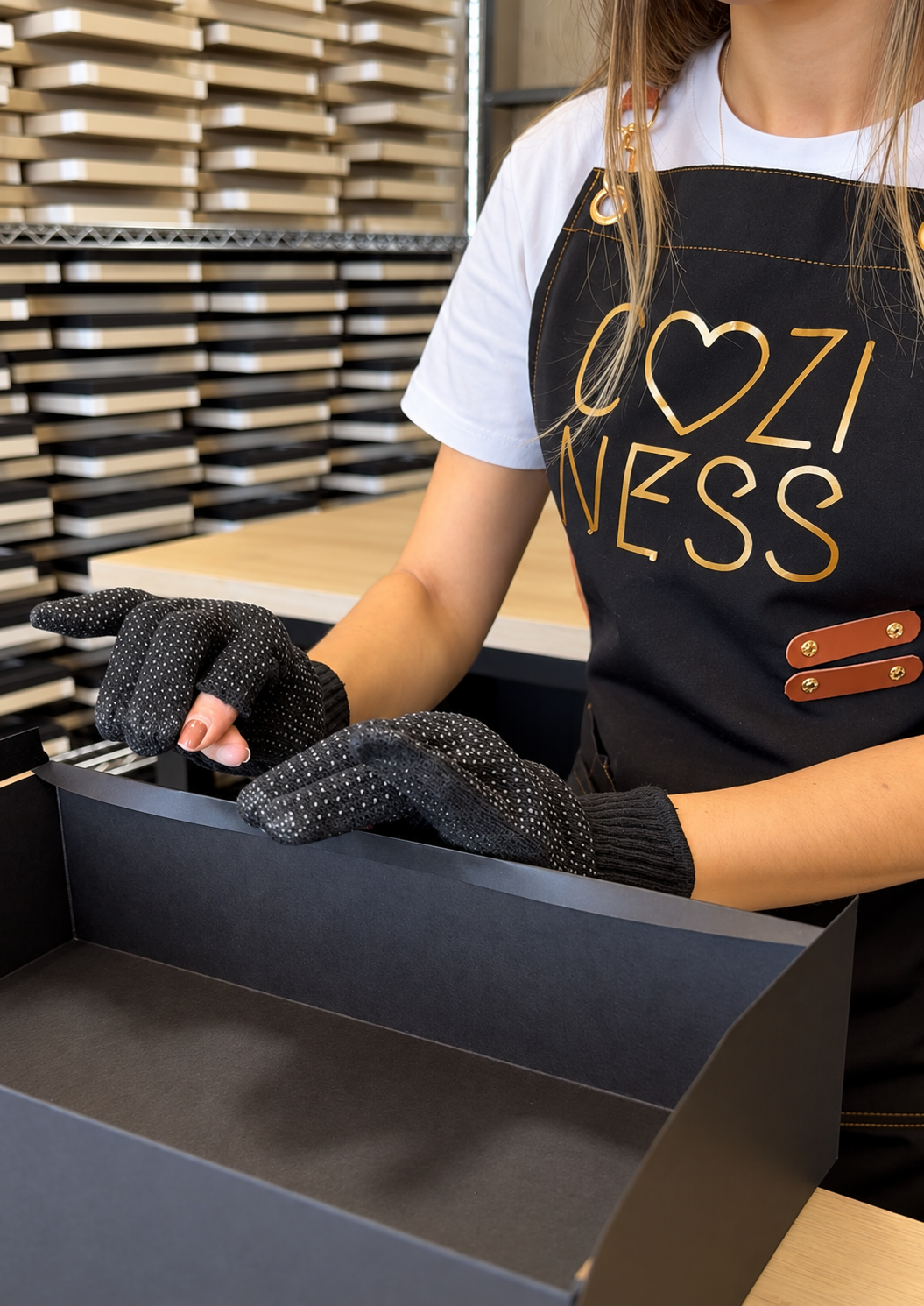 Colaboradora da Coziness montando uma caixa cartonada na produção própria